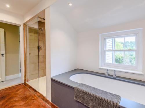 3 Bed in Faversham 78880 في فيفرشام: حمام كبير مع حوض استحمام ونافذة