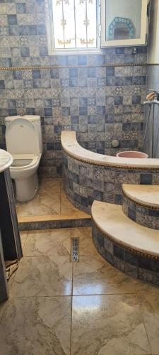 a bathroom with a toilet and a tub and a sink at Dar Souade in Chott Meriem