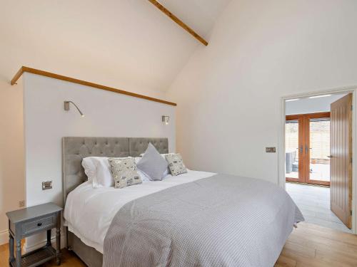 een slaapkamer met een groot bed met witte lakens en kussens bij 1 Bed in Filey 79277 in Wold Newton
