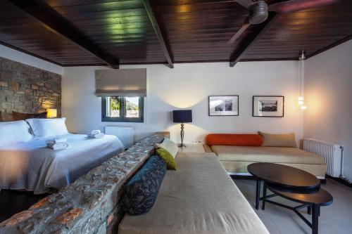 カト・トリカラ・コリンティアスにあるGuesthouse Diochriのベッド、ソファ、テーブルが備わるホテルルームです。