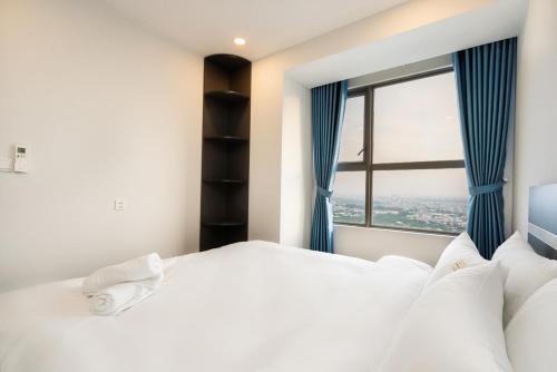 Un dormitorio con una gran cama blanca y una ventana en River panorama 2Bedroom*Kingbed*Infinity Pool, en Ho Chi Minh