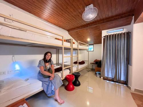 a woman sitting in a room with bunk beds at Green Valley Vista in Munnar