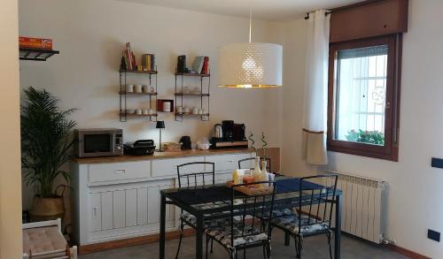 a kitchen with a table with chairs and a microwave at Art-Apart LT appartamento con giardino privato in Padova