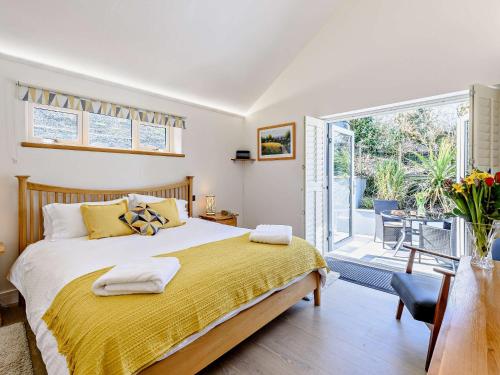um quarto com uma cama grande e uma varanda em 3 Bed in Woolacombe 82159 em Marwood