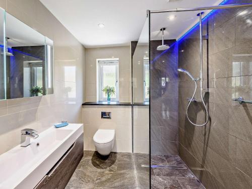 a bathroom with a shower and a toilet and a sink at 3 Bed in Woolacombe 82159 in Marwood