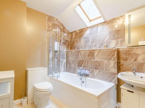 a bathroom with a tub and a toilet and a sink at 4 Bed in Brixham 82519 in Brixham
