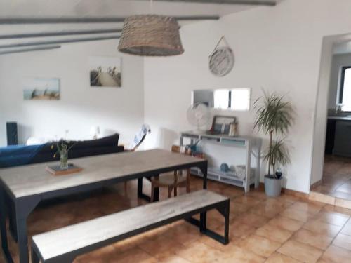 un salon avec une table et un canapé dans l'établissement MAISON PAISIBLE , à 6 minutes des plages, vélos., au Château-dʼOléron