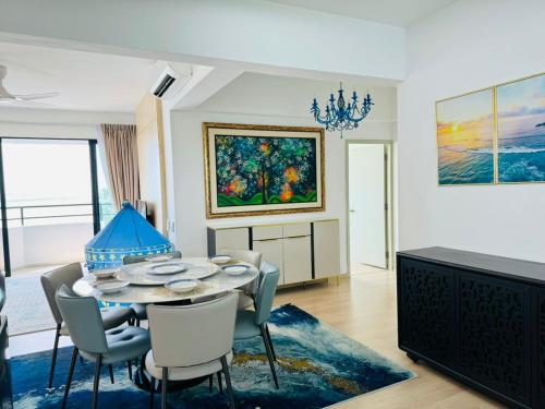 a dining room with a table and chairs and a painting at Mutiara Melaka Beach Resort by Minso in Tangga Batu