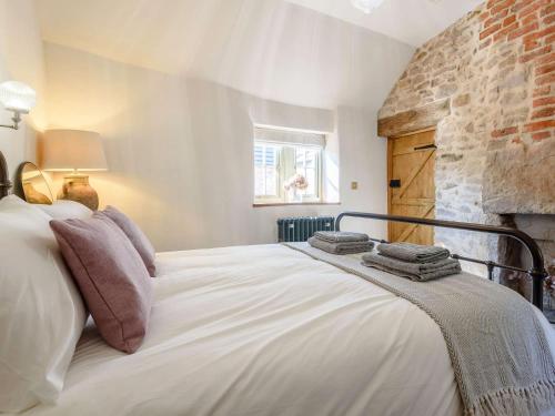 Un dormitorio con una gran cama blanca y una pared de ladrillo en 3 Bed in Belper 83037 en Hazelwood