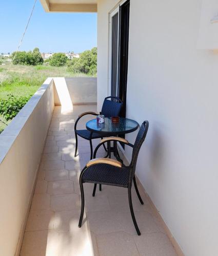 a patio with two chairs and a table on a balcony at Malamo Home Studios, Lambi Beach in Lampi