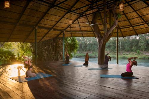 a group of people doing yoga in a pavilion at The Namkhan, a Small Luxury Hotel of the World in Luang Prabang