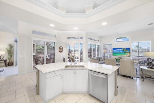 a kitchen with a sink and a living room at Elegantly decorated waterfront home with pool and spa in Marco Island