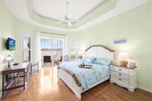 a bedroom with a bed and a desk and a table at Waterfront home with views, pool and walk to beach in Marco Island