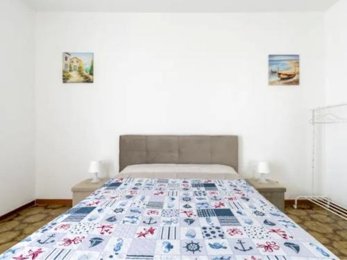 a bed in a bedroom with two pictures on the wall at DREAM HOUSE Casa Vacanze in Arma di Taggia
