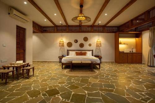 a bedroom with a bed and a table and chairs at SaffronStays Athaang, Dapoli in Ānjarle