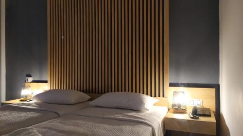 a bedroom with two beds and a large headboard at Hotel Plaza in Kalamata