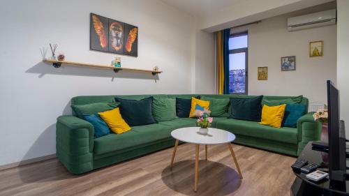 a living room with a green couch and a table at Apartment in Tbilisi “Green Budapest “ in Tbilisi City