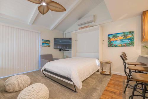 a bedroom with a bed and a table and chairs at Shores Of Maui 224 in Kihei