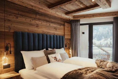 two beds in a room with wooden walls at Luxury Chalet P in Ortisei