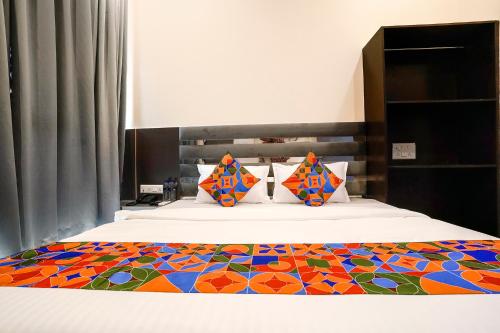 a bedroom with a bed with a colorful quilt at FabHotel Freedom International in Mumbai