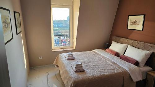een slaapkamer met een groot bed en een raam bij Apartman Fort in Stara Pazova