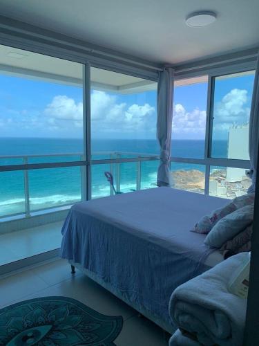 a bedroom with a bed and a view of the ocean at DUETTO Barra in Salvador