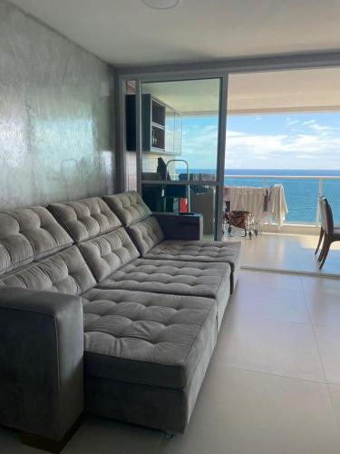 a large couch in a living room with a view of the ocean at DUETTO Barra in Salvador