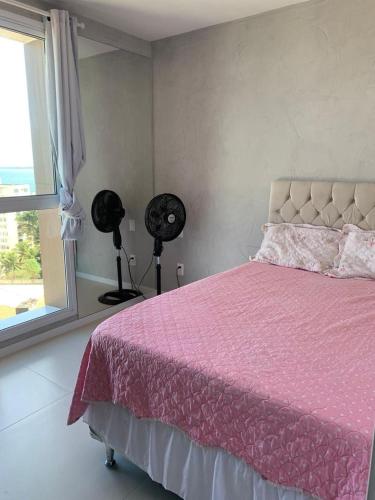 a bedroom with a pink bed and a window at DUETTO Barra in Salvador