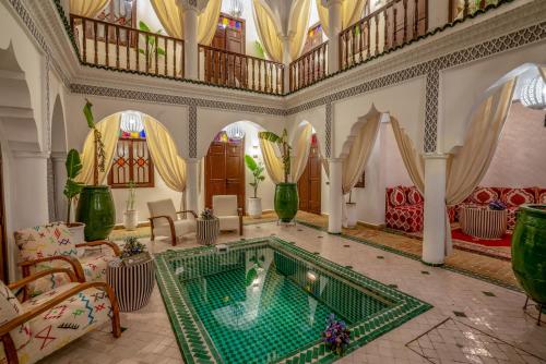 - un salon avec une piscine au milieu d'une pièce dans l'établissement Riad Ekla Boutique Hotel, à Marrakech