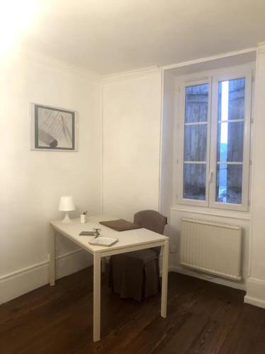 - un bureau blanc dans une chambre avec fenêtre dans l'établissement La maison de Jeanne, à Santenay