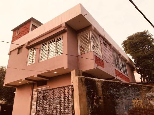 una casa rosa con una valla delante en Hotel Shiva , Bodh Gaya, en Bodh Gaya
