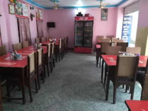 a dining room with tables and chairs and pink walls at Hotel Shiva , Bodh Gaya in Bodh Gaya