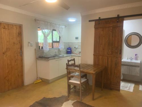 a kitchen with a wooden table and a wooden cabinet at Vlakkieskraal FarmStay - Bosvark Cabin in Bela-Bela