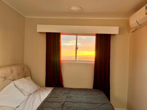 a bedroom with a window with a view of the ocean at 1 bedroom condominium in Lapu2x in Lapu Lapu City