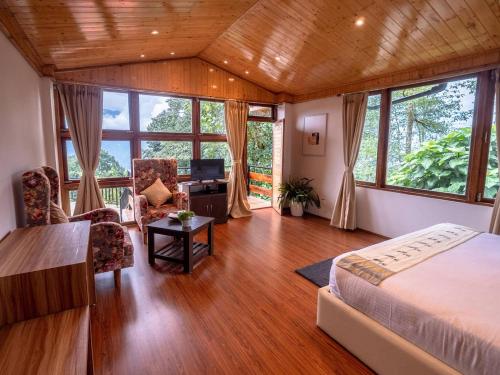 a bedroom with a bed and a desk at Kaya Gantavya Resort in Pelling