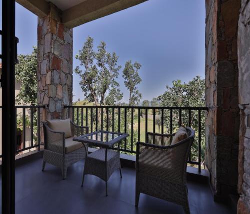 a balcony with a table and chairs and a view at Sajjan Bagh Resort Kumbhalgarh in Kumbhalgarh