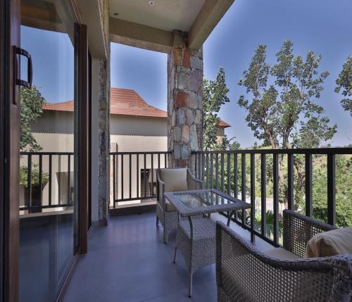 a porch with chairs and a table on a balcony at Sajjan Bagh Resort Kumbhalgarh in Kumbhalgarh