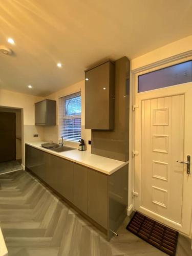 una cucina con porta bianca e bancone di A home away from home a Manchester