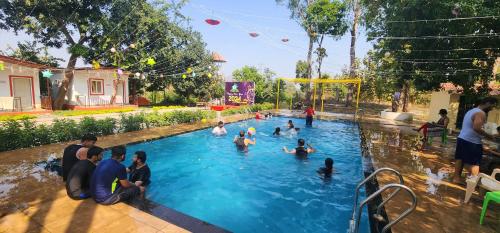 un groupe de personnes dans une piscine dans l'établissement Dsouza's Nature Farm, à Badlapur