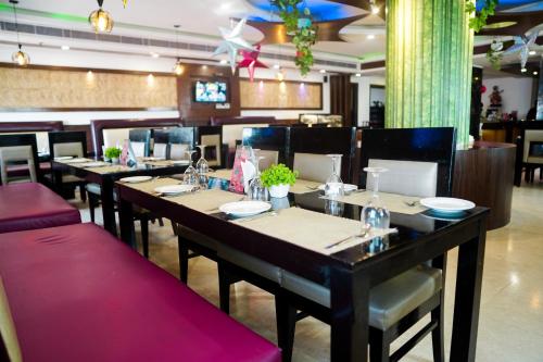 a dining room with tables and chairs in a restaurant at The Vaishnavi in Deoghar