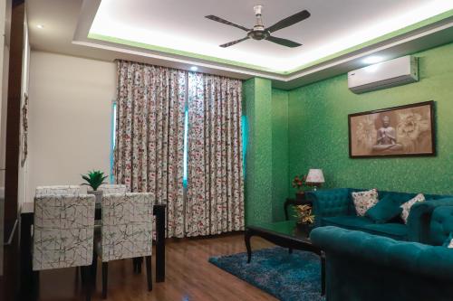 a living room with a blue couch and a table at The Vaishnavi in Deoghar