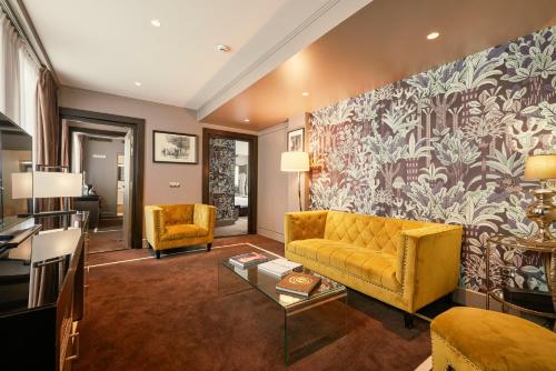 a living room with a yellow couch and a wall mural at Juliana Hotel Paris in Paris