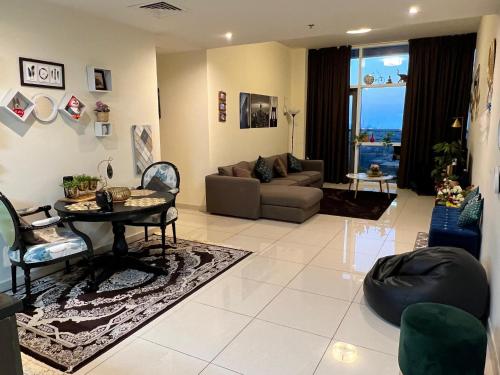 Luxurious 2 Bedroom 5 Mins from Burj Khalifa في دبي: غرفة معيشة مع أريكة وطاولة