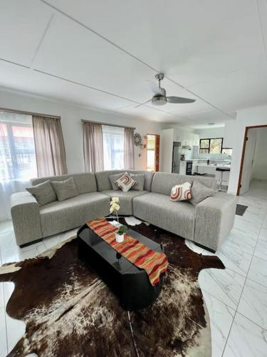 a living room with a couch and a table at Luxury 1 Bdr Garden Cottage in Windhoek