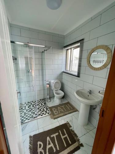 a bathroom with a sink and a toilet and a shower at Luxury 1 Bdr Garden Cottage in Windhoek