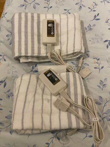 a bed with towels and an ipod on it at Namba Shinsaibashi 10 mins Reiko guest house in Osaka