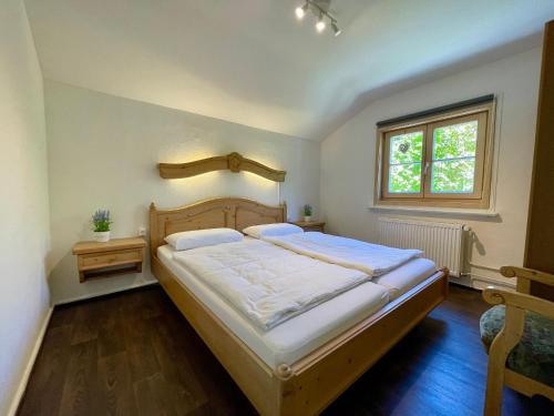- une chambre avec un grand lit et une fenêtre dans l'établissement Forsthaus Reit im Winkl, à Reit im Winkl