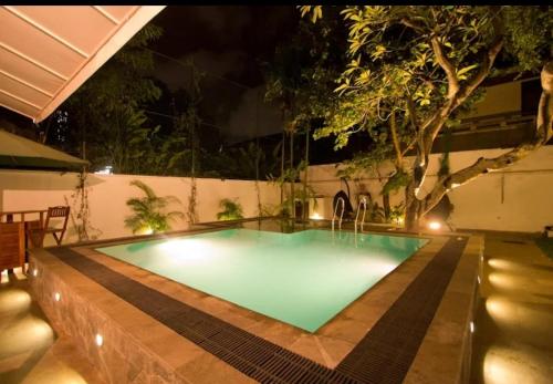 a swimming pool in a backyard at night at Ellen’s Place in Colombo