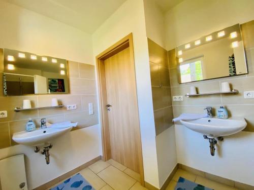 ein Badezimmer mit zwei Waschbecken und zwei Spiegeln in der Unterkunft Ferienhaus Stoertebeker in Warnemünde
