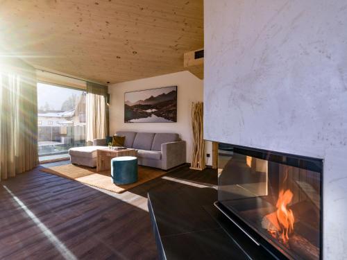 a living room with a fireplace and a couch at Villa Himmlgassl Private Spa in Zellbergeben